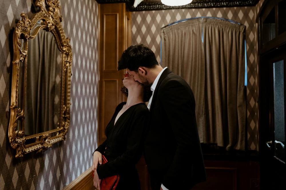 A man in a suit kissing a woman 