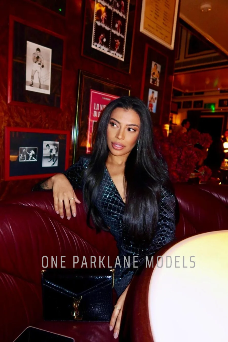 Anitta sitting in a bar on a leather couch